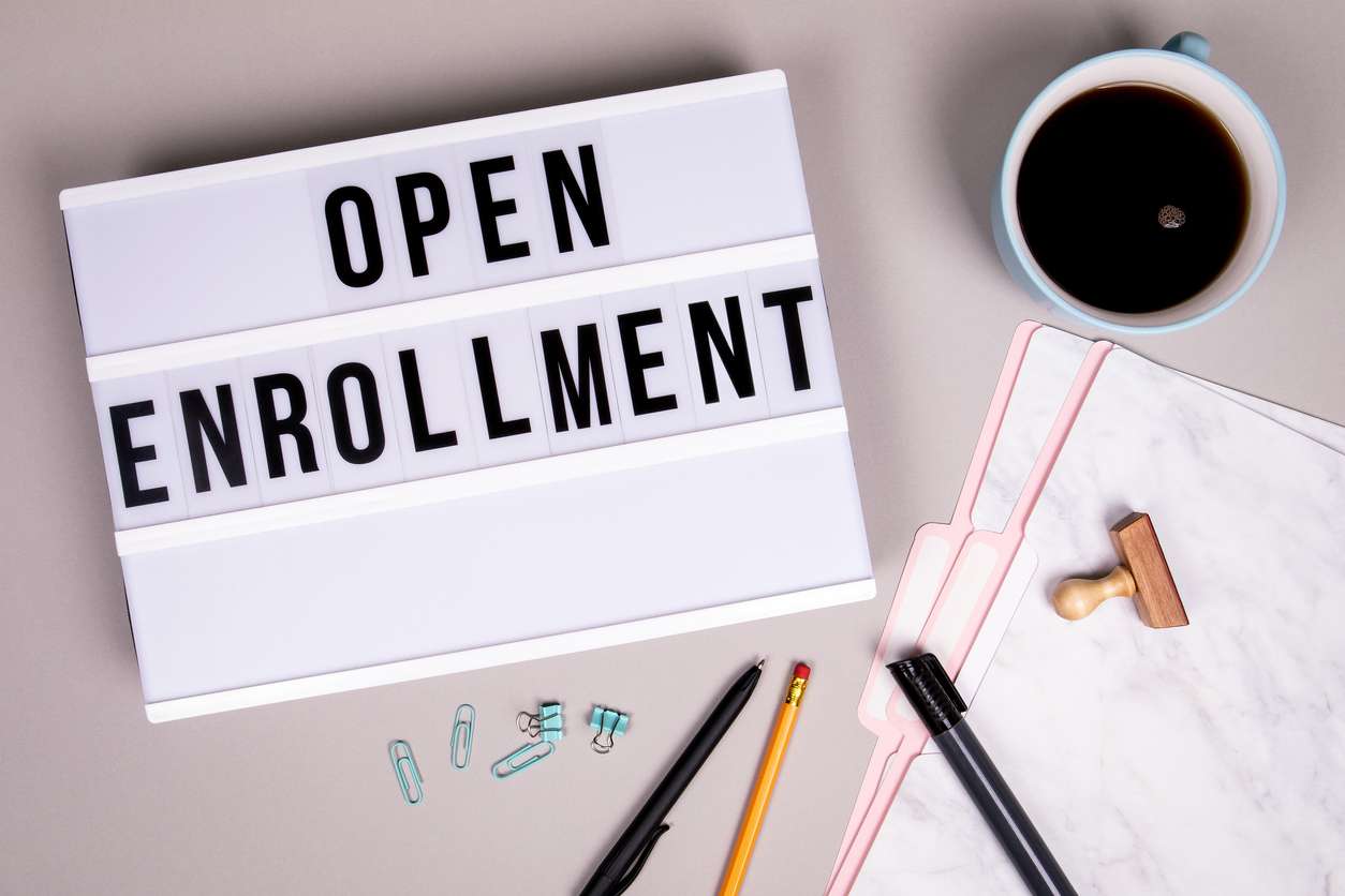 Open Enrollment concept. White lightbox on a gray office desk
